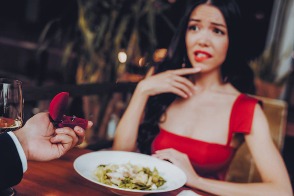 Man Proposing Engagement Ring and Getting Denied. Romantic Hispanic Couple in Love Dating. Cutel Man and Girl in a Restaurant. Romantic Concept. Negative Reaction to Proposing. Disappointment. - Photo, Image