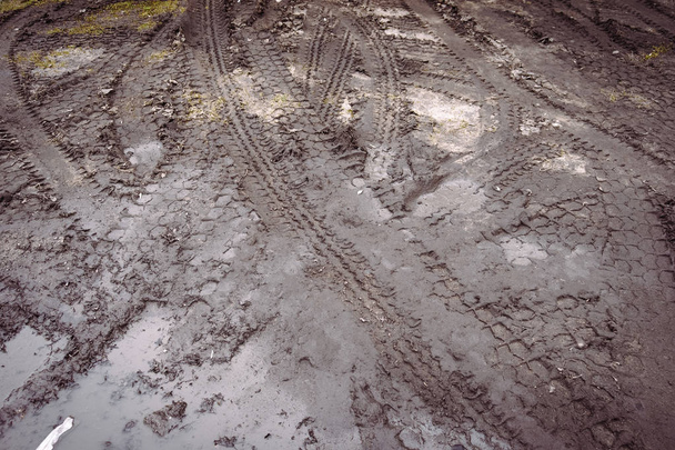 Gumiabroncs nyomon követi a sáros úton. - Fotó, kép