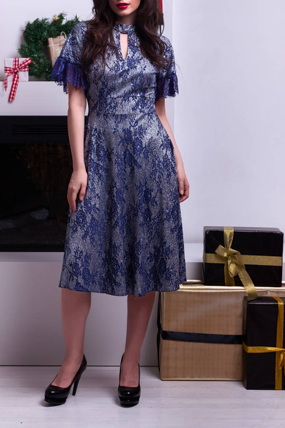 正月背景にポーズかなり青いドレスで美しいエレガントな若いブルネット女性のファッション写真。新年のファッショントレンド - 写真・画像