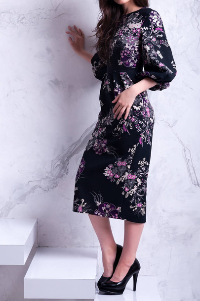 Sensuelle belle femme brunnete posant en robe florale noire. Fille avec de longs cheveux bouclés.
 - Photo, image
