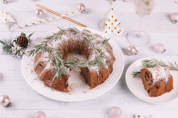 Традиционный рождественский фруктовый торт на белом деревянном столе. Домашний пудинг с праздничными украшениями, леденцы
 - Фото, изображение