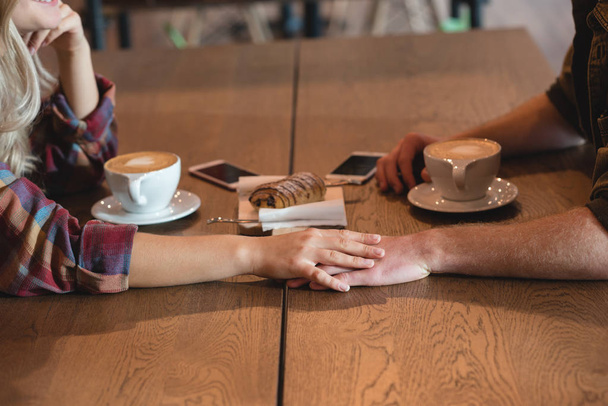 Romantyczna para trzymając rękę w kawiarni - Zdjęcie, obraz