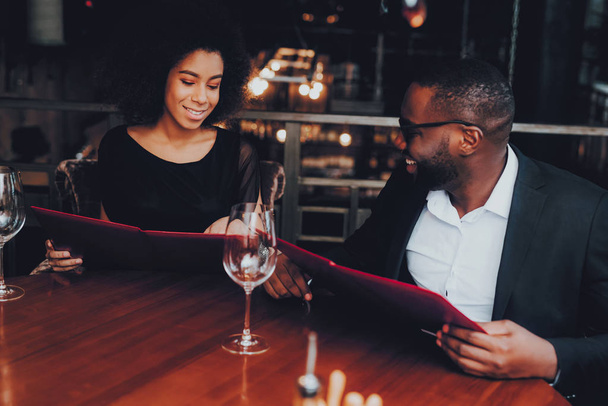 African American Couple Dating in Restaurant. Romantic Couple in Love Dating. Cheerful Man and Woman with Menu in a Restaurant Making Order. Romantic Concept. Anniversary. Date. Love. - Фото, зображення