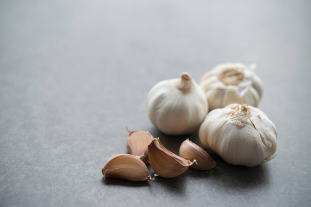 Garlic cloves and bulb with copy space on dark background. - Zdjęcie, obraz