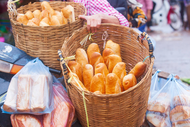 Baguette tai ranskalaista leipää bambu korit moottoripyörä. Perinteistä ruokaa Laosissa ja Indokiinassa. Laosin tyyliin. Pakse Market, Champasakin maakunta, Laos
. - Valokuva, kuva