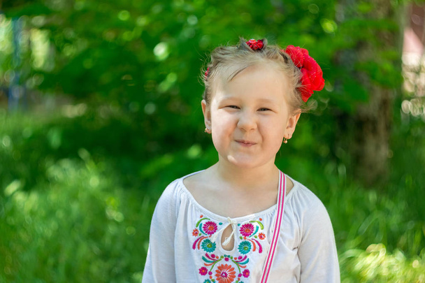 Pequeña niña ucraniana en vestido rojo
. - Foto, imagen