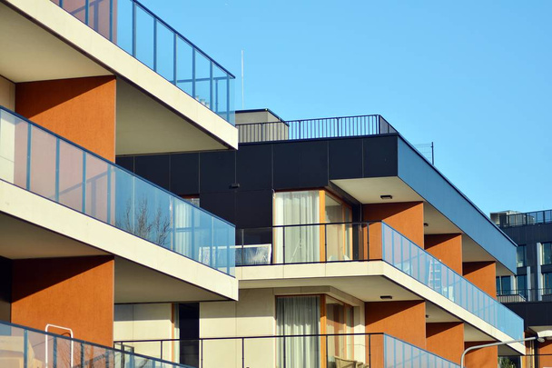 Nowoczesne budynki mieszkalne w słoneczny dzień z błękitnym niebem. Fasada nowoczesnego apartamentowca - Zdjęcie, obraz