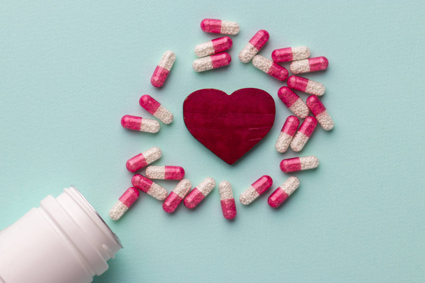 Red heart with pills on table - Foto, Imagen