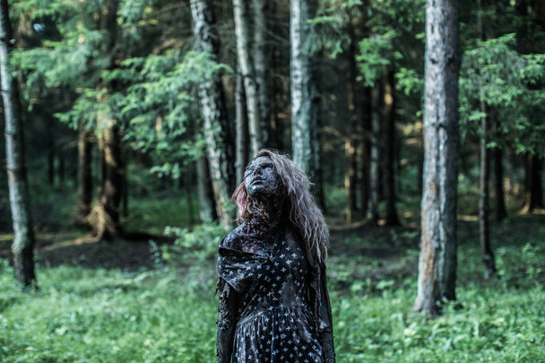 Scary zombie woman posing at forest path - Foto, Imagem