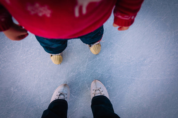 mother and child learning to skate in winter - Foto, Bild