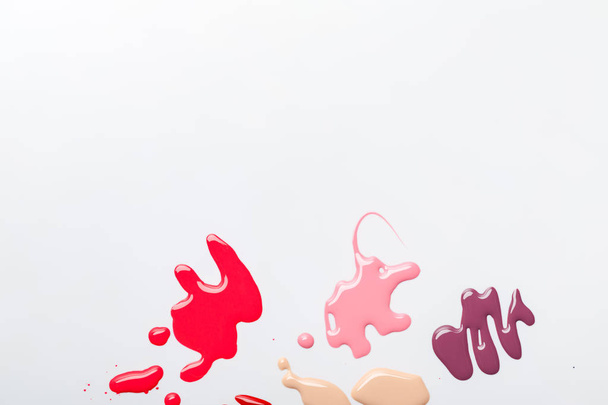 vista superior de derrames húmedos multicolores de esmalte de uñas aislado en gris
 - Foto, Imagen
