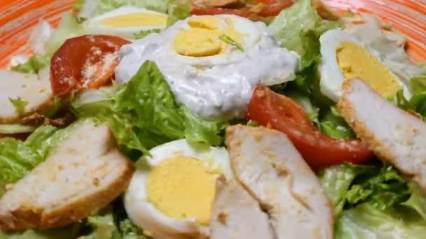 Salát Caesar v červené desky. Caesar salát se skládá z Pečené kuřecí prsa, ledový salát, rajče, sýr parmezán. Oblíbené jídlo z evropské kuchyně a kuchyně jiných zemí světa. - Záběry, video