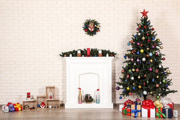 Decorated fireplace near christmas tree on brick wall background - Zdjęcie, obraz