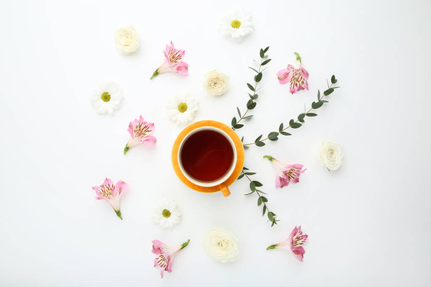Flowers with cup of tea on white background - Fotoğraf, Görsel