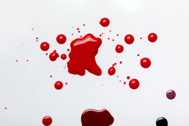 vista superior de derrames rojos abstractos con gotas aisladas en gris
 - Foto, Imagen