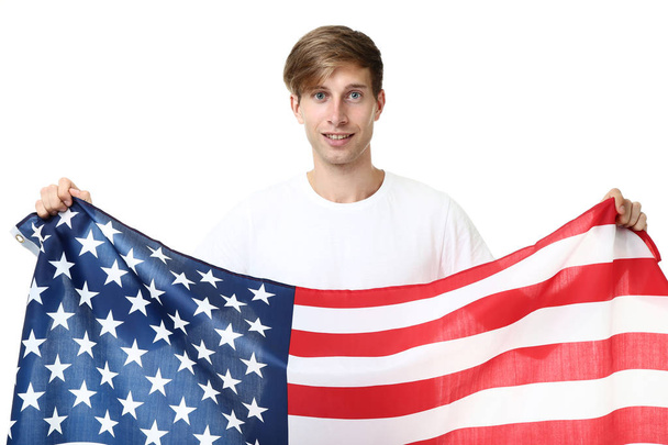 young man holding an American flag on white background - Foto, imagen