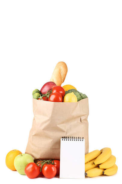 Grocery shopping bag with food and blank notepad isolated on white background - 写真・画像