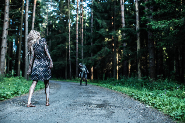 Zombie man and woman posing together at forest - Фото, изображение