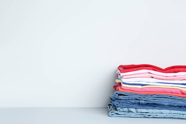 Stack of folded clothes on grey background - Foto, imagen