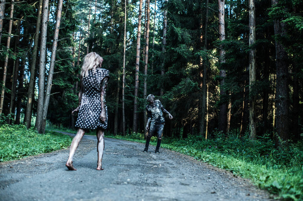 Zombie man and woman posing together at forest - Foto, Imagem