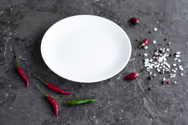 Белая тарелка на сером бетонном фоне. Подготовка к приготовлению пищи. Его можно использовать в качестве фона
 - Фото, изображение