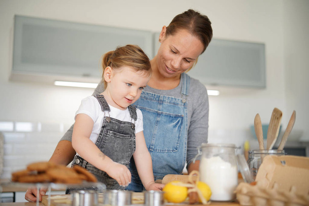   Mother and daughter baking at home                              - 写真・画像