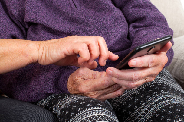 Picture of a senior woman hand using a smartphone - Foto, Imagem