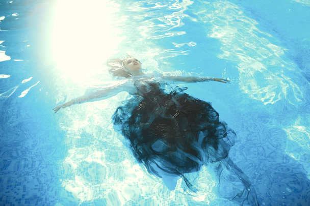 Beautiful model is posing in a swimming pool - 写真・画像