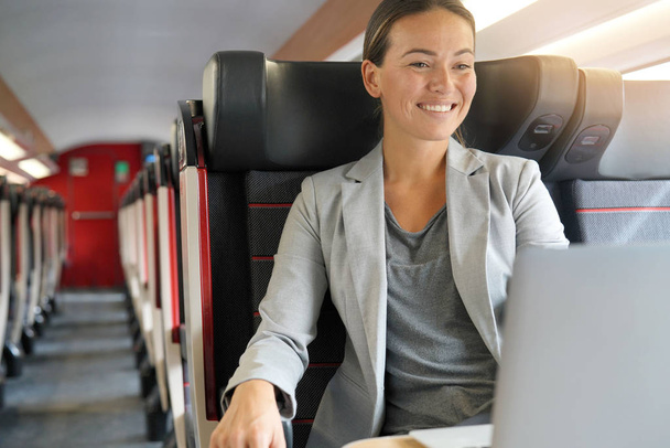 Young businesswoman working in first class on a train                               - Foto, afbeelding