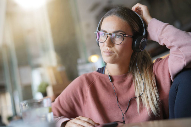  Young woman inside an urban space with headphones and devices                               - Photo, Image
