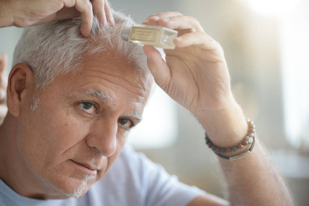Senior man treating hair loss - Фото, изображение
