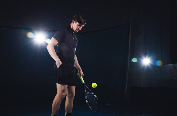 A man is playing tennis. A man in a red T-shirt beats a tennis ball. - Fotoğraf, Görsel