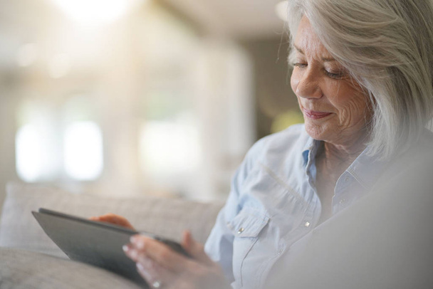  Senior woman at home with tablet                             - Foto, Imagen