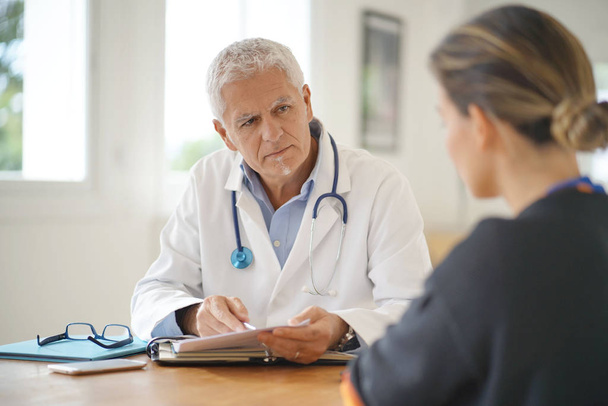 Doctor talking to patient in office - Photo, image