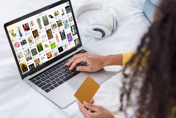 image recadrée de la femme tenant la carte de crédit et en utilisant un ordinateur portable avec pinterest à l'écran
 - Photo, image