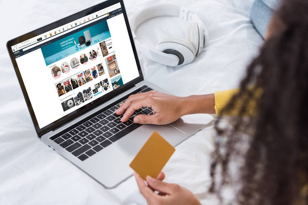 女性のクレジット カードを保持していると画面にアマゾンでラップトップを使用して画像をトリミング - 写真・画像