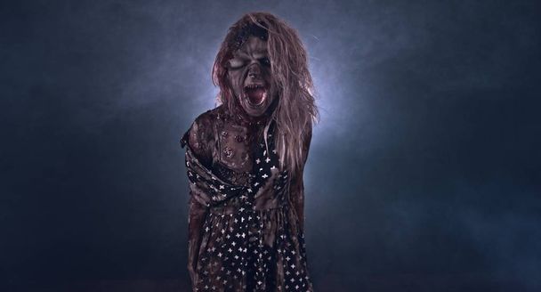 Creepy zombie woman posing against dark background - Fotó, kép
