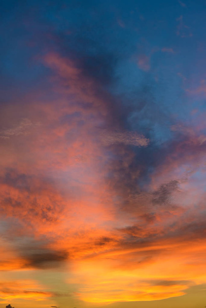 Piękny zmierzchu niebo chmura dramatyczne pomarańczowy i niebieski kolor. - Zdjęcie, obraz