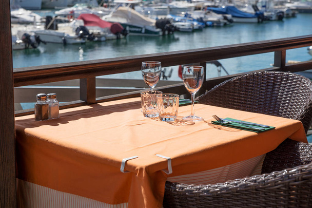 Mesa vacía en el restaurante al aire libre en el puerto
 - Foto, Imagen