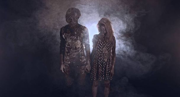 portrait of zombies together against dark misty background - Foto, afbeelding