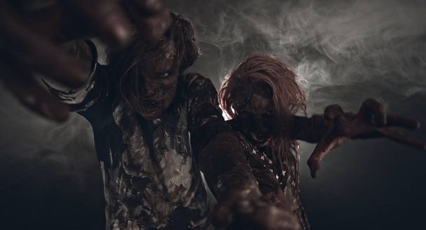 két zombik pózol együtt sötét háttér portréja - Fotó, kép