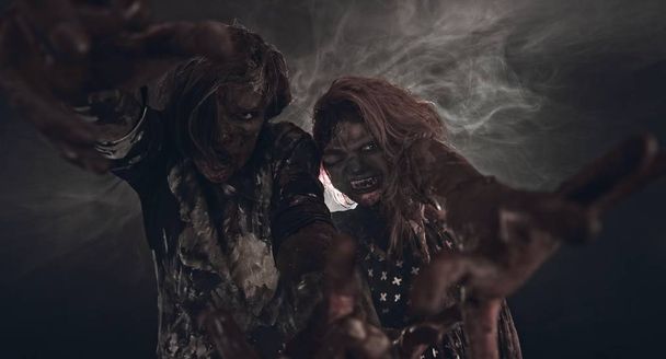 portrait of two zombies posing together against dark background - Foto, Imagem