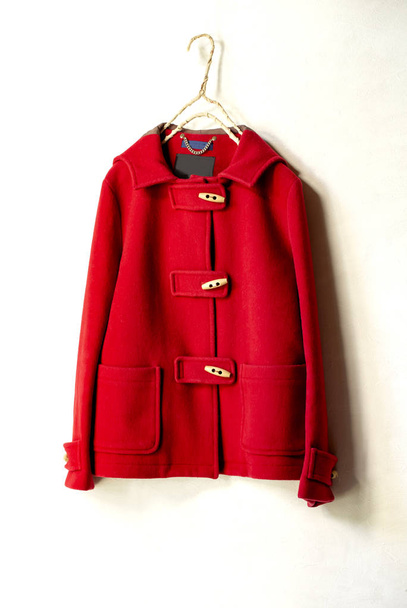 red wool short coat hanging on clothes hanger on white background - Foto, Imagem