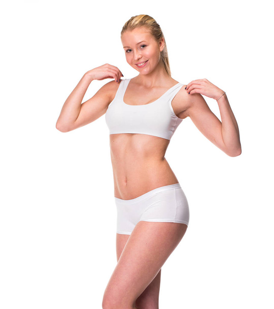 Portrait of a young blonde woman in sportswear without makeup. Sexy beautiful model in white fitness clothing, isolated on white background - Foto, Imagem