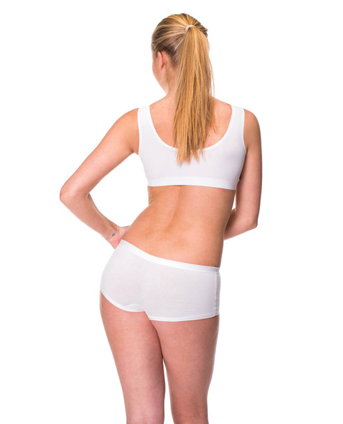 Mulher loira vestindo lingerie esportiva branca, vista traseira, isolada no fundo branco
 - Foto, Imagem