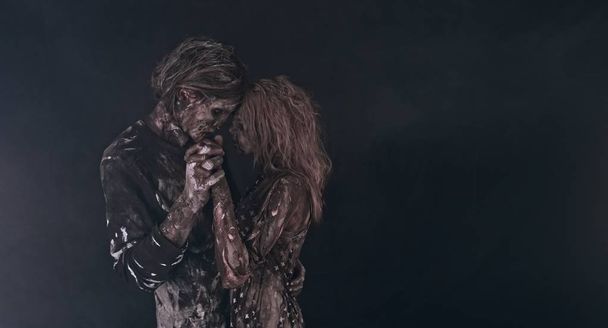 portrait of tender zombie couple hugging together against dark background - Fotografie, Obrázek