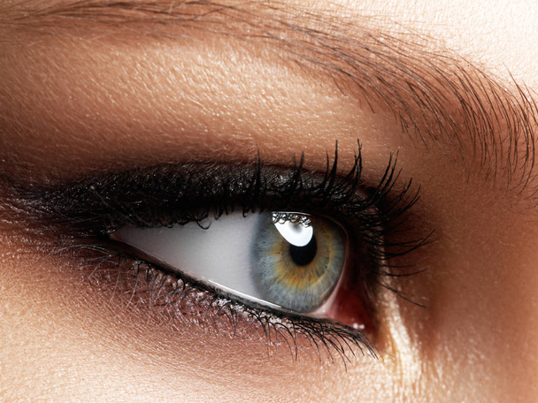 Primer plano de ojo de mujer azul con hermoso marrón con tonos de maquillaje ojos ahumados. Maquillaje de moda moderna. Maquillaje desnudo. Piel limpia, pestañas largas
 - Foto, imagen