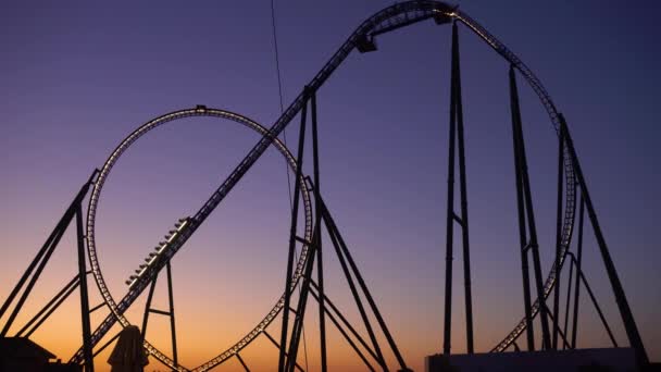 Silhouette of roller coaster against sunset sky - Footage, Video