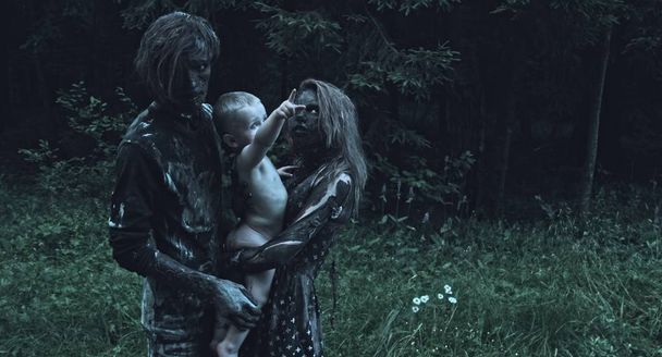 Zombie couple hugging little human baby at forest - 写真・画像