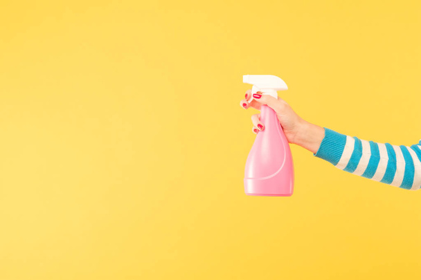female hand hold sprayer yellow cleaning housework - Foto, afbeelding